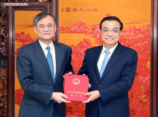 Chinese Premier LiKeqiang (R) presents a contract to Qian Yingyi, a new counselor ofthe State Council, in Beijing, China, Feb. 9, 2015. Li presentedcontracts to new counselors of the State Council and members of theCentral Institute of Culture and History (CICH) here on Monday. Healso attended a symposium with the newly appointed counselors andCICH members. (Xinhua/Yao Dawei)