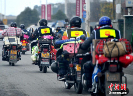 Migrant workers drive over a thousand miles back to their hometowns on their motorcycles for the upcoming Spring Festival on February 9, 2015. Riding home by motorcycles has become a special phenomenon during the Spring Festival travel rush which started earlier this month. [Photo/Chinanews.com]