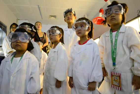 Children learn to repair fossils at a lab in the Paleozoological Museum of China, in Beijing, October 2014. [Photo by Li Zhiming/provided to chinadaily.com.cn]  