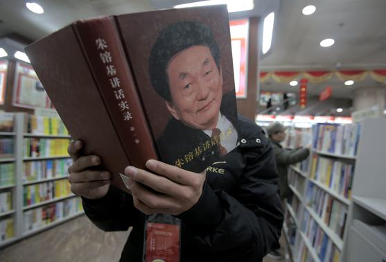 A reader browses Zhu Rongji's Answers to Journalists' Questions at Wangfujing Bookstore in Beijing on Tuesday. WANG JING/CHINA DAILY  
