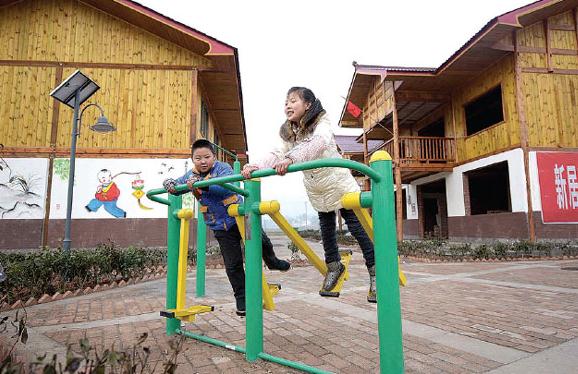 Two children play at a newly constructed residential area of Qinglongchang village of Lushan county in Sichuan province last week. Xue Yubin / Xinhua