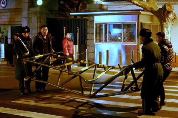 The damaged barrier is carried away from the South Urumqi Road entrance of the consulate in Shanghai late on Thursday night. [Provided to China Daily]