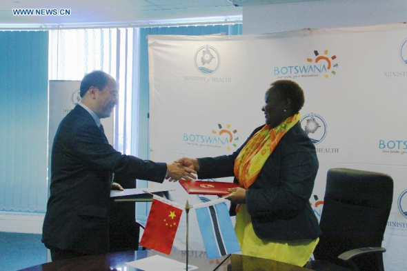 Chinese Ambassador to Botswana Zheng Zhuqiang (L) shakes hands with Botswana's Health Minister Dorcas Makgato during the signing ceremony of agreement of sending the 14th China medical team to Botswana, in Gaborone, capital of the country, on Feb. 13, 2015. China and Botswana on Friday signed an agreement on China's sending the 14th medical team with 46 members, including 30 doctors, 10 nurses and 6 staff, to Botswana. (Xinhua/Huang Kai)