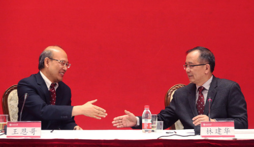 Wang En'ge, former Peking University president (left), greets his successor, Lin Jianhua, on Sunday. Wang Tiantian / for China Daily