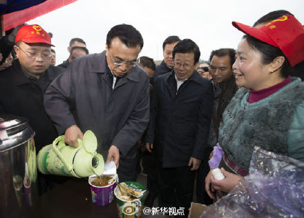 Premier Li Keqiang, center, makes instant noodles for migrant workers at a reception center in Liping county, Guizhou province, Feb 14, 2015. [Photo/Sina Weibo]  