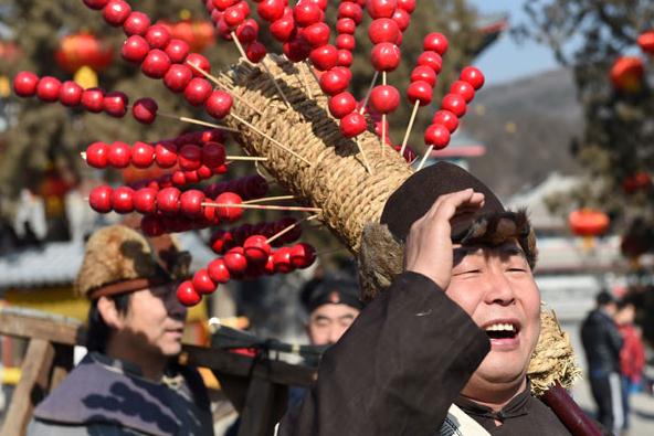 A performer practices crying out his wares as a street vendor at Badachu Park on Feb 9.[Photo by Li Jundong/China Daily]  