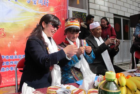 A Han woman (left) and a Tibetan girl make traditional local food in Lhasa on Sunday, to greet Spring Festival and Tibetan New Year, both of which come on Thursday. Palden Nyima / China Daily