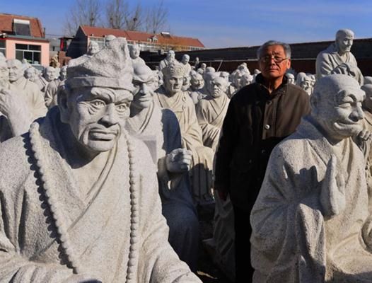 Sculptor Chen Xiulin with statues of the arhats at his residence-cum-studio on the outskirts of Weifang city in Shandong province. (Photo provided To China Daily) 