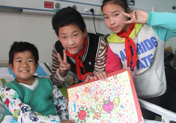 Zhu Feng (left) poses with students of a school for the hearing-impaired at Zhongnan Hospital of Wuhan University in Hubei province. Provided to China Daily