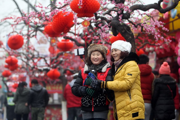 Two women take a photo with a selfie stick at a temple fair in Beijing on Feb 20. Photo / Xinhua