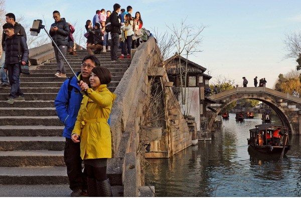  A couple takes a photo with a selfie stick near an ancient bridge in Zhejiang province on Jan 2. Photo / Xinhua
