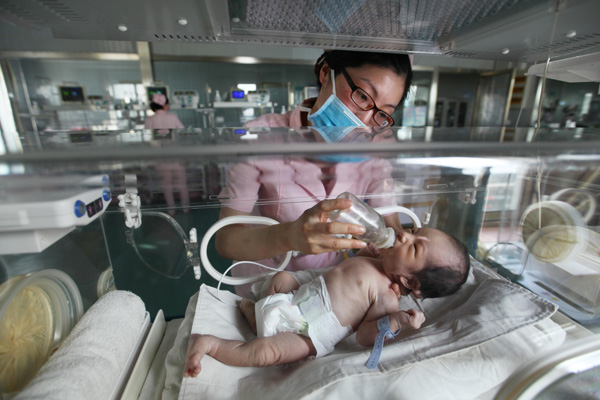 A newborn is cared for in an incubator. Maternity units such as this at Lianyungang, Jiangsu province, are experiencing a big increase in the number of births, and experts expect an even greater rise in the years ahead. (PHOTO: CHINA DAILY/SI WEI)