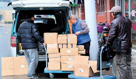 Courier company staff load parcels into a van yesterday in downtown. Deliveries began to get back to normal after the Spring Festival break. (Photo: Shanghai Daily/Zhang Suoqing)