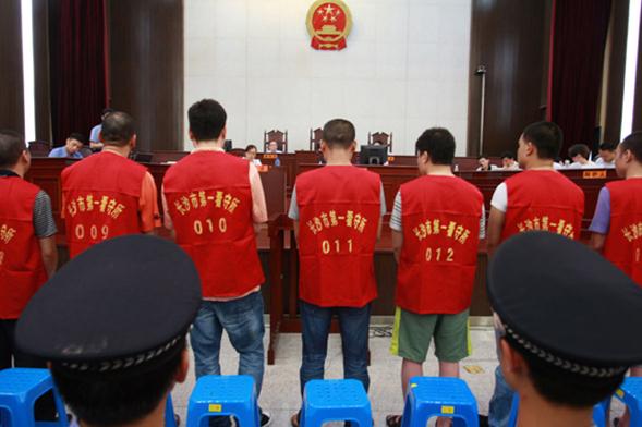 Suspects clad in detainee uniforms appear at a trial in Intermediate People's Court of Changsha, Hunan province, in July. (Photo by Zhou Qiang/for China Daily)