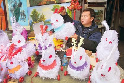 A shop owner puts out rabbit lanterns to sell yesterday in a downtown spot near Yuyuan Garden.