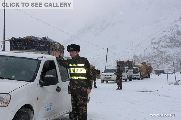 Photo taken on Feb. 27, 2015 shows police officers guiding vehicles stranded due to mudslide at a section of the Sino-Pakistan Highway in northwest China's Xinjiang Uygur Autonomous Region. The mudslide caused over 500 people and at least 100 vehicles stranded. (Photo: Xinhua/Han Guangning)