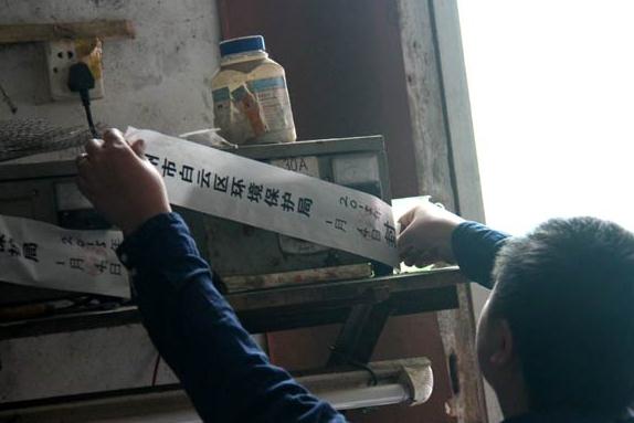 Equipment at a watchmaking plant is sealed by a member of the environmental supervision team of Guangzhou, Guangdong province, on Jan 4 after the company was found to be seriously polluting the surrounding environment. (Photo/China Daily)