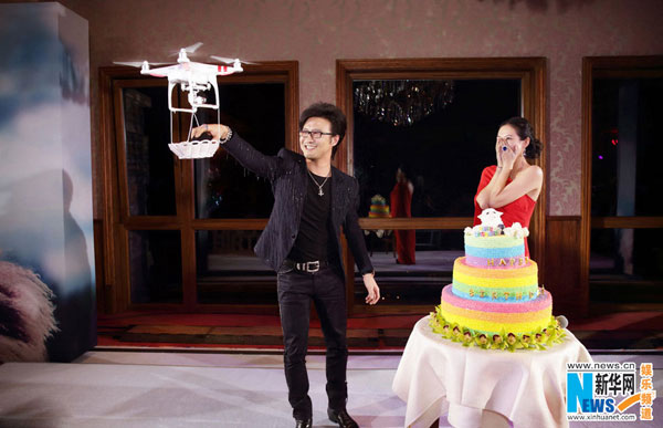 Wang Feng takes an engagement ring from a basket, delivered by drone. (Photo/Xinhua)