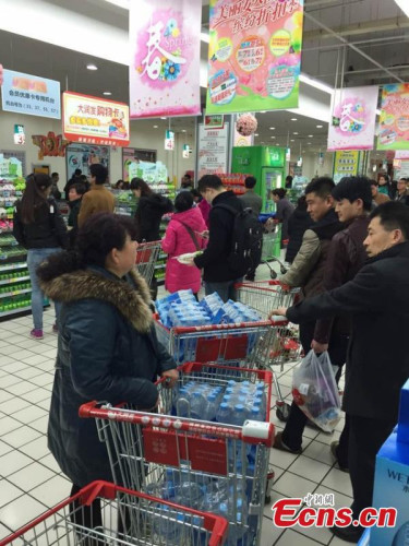 Customers wait to pay after buying bottled water at a supermarket in Lanzhou, Northwest Chinas Gansu province, March 4, 2015. (Photo/CFP) 
