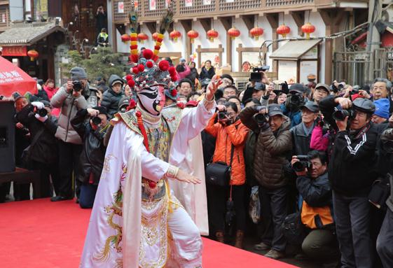 Visitors have their cameras at the ready as an artist performs during the Fushansuo Temple Fair in Qingdao, East Chinas Shandong province, March 3, 2015. (Photo/provided to chinadaily.com.cn)