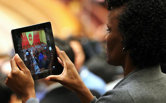 A foreign journalist takes a photo during the opening session of the National People's Congress in Beijing March 5, 2015. (Photo/China Daily)