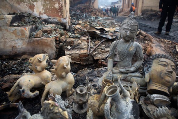 Buddha statues lie among the wreckage after a fire destroyed hundreds of buildings in Dukezong, Yunnan province, on Jan 10, 2015. The town is known for its well-preserved Tibetan buildings. PROVIDED TO CHINA DAILY