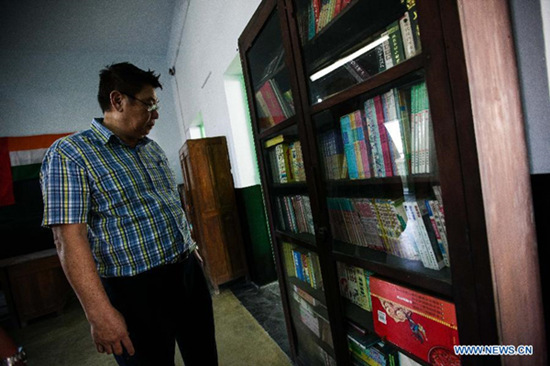 Chinese Indian Wu checks the books at Pei May Chinese High School in Tangra of Kolkata, West Bengal of India, March 8, 2015. Located in the China town of Kolkata, Pei May Chinese High School, said to be one of its kind in India for Chinese overseas in the city, is being painted and to be re-opened. (Xinhua/Zheng Huansong) 