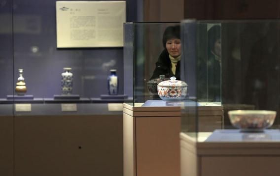 A visitor views an ancient porcelain exhibition in the Palace Museum in Beijing. (Photo: Jiang Dong/China Daily)