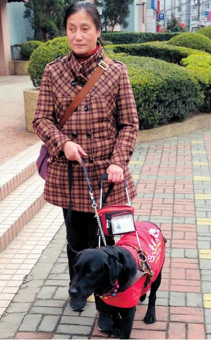 Huang Ming with her guide dog. (Photo/Shanghai Daily)