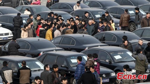 Buyers check some of the official vehicles to be auctioned at Yayuncun Vehicle Trading Market in Beijing, Jan 25, 2015. The first batch of 304 premium sedans formerly owned by the central government was auctioned off in Beijing on Sunday. [Photo: China News Service/Yang Yanyu]