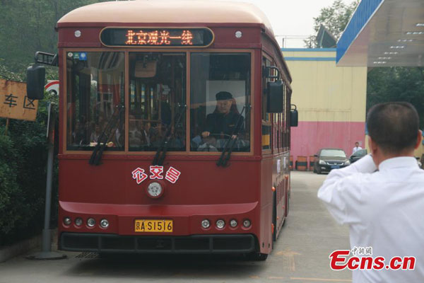 A tour bus which preserves the classic look of Dangdang trolley departs from a bus stop in Beijing, Sept 28, 2014. (Photo/China News Service)