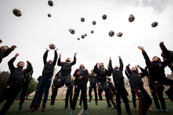 Primary school students in Hefei, Anhui province, mark the start of a new semester on March 2. An overall plan for soccer reform and development was unveiled on Monday, including expanding the soccer system in schools. (Photo/Xinhua)  