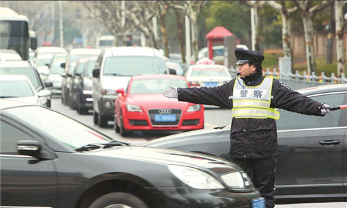 A police officer directs traffic near the Pudong entrance of the Renmin Road Tunnel yesterday, the first working day after the closure of a section of the Yanan Road E. Tunnel, one of the citys busiest tunnel under Huangpu River. (Photo: Shanghai Daily/Wang Rongjiang)