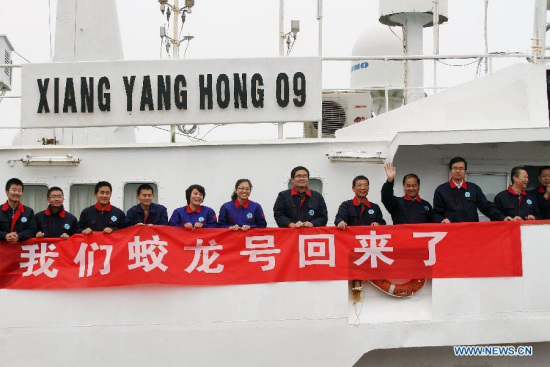 Scientific researchers of China's deep-sea manned submersible Jiaolong wave hands upon their arrival in Qingdao, east China's Shandong province, March 17, 2015.(Photo: Xinhua/Lin Xiaomu) 