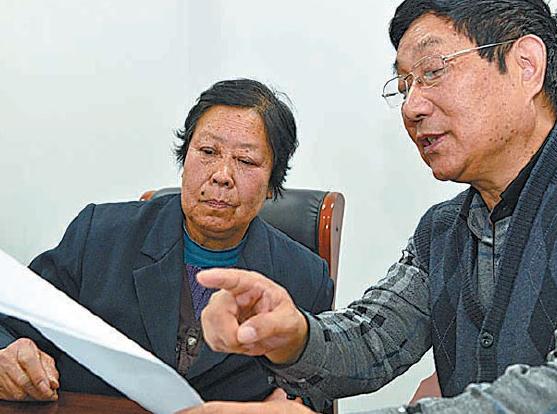 Lawyer Chen Guangwu reviews files of Nie Shubin's case with Zhang Huanzhi, Nie's mother, at Shandong High People's Court on Tuesday. Nie may have been wrongfully executed, they say. (Photo: Guo Xulei/Xinhua)