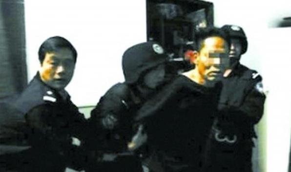 Peng Jiaxiang, second from right, is handcuffed during a police crackdown on fake money in South China's Guangdong province in this undated file photo. (Photo/xinhuanet.com)