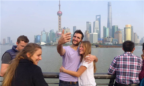 Tourists take photos on the Bund today as the mercury climbs to 20 degrees in Shanghai. Forecasters said tomorrows high will further hit 24 degrees Celsius but drop to the mid teens on Thursday. The mercury will claw its way to 18 degrees on Friday but dip to 16 on Saturday. (Photo: Shanghai Daily/Wang Rongjiang)