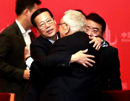 Vice-Premier Zhang Gaoli (left) greets former US secretary of state Henry Kissinger with a hug at the China Development Forum 2015 in Beijing, March 22, 2015. (Feng Yongbin/China Daily)  