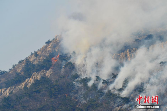 Photo taken on March 22, 2015 shows smoke rising from the Dahei Mountain in northeastern Chinese city of Dalian. (Photo: China News Service/Liu Debebin)