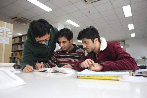 A university student from Pakistan (C) discusses with classmates at Northwest Polytechnical University in Xi'an, Shaanxi province, Dec 10, 2014. (Photo/Xinhua)  