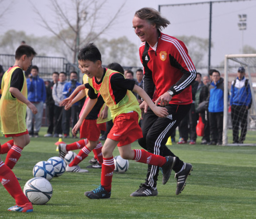Soccer coach Jan Olde Riekerink, former head of youth development at Dutch club Ajax, trains youngsters at a primary school in Beijing on Wednesday. (Photo/China Daily)  