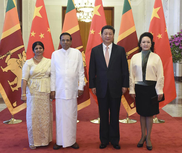 Chinese President Xi Jinping (2nd R) and his wife Peng Liyuan (1st R) pose for a group photo with Sri Lankan President Maithripala Sirisena (2nd L) and his wife during a welcoming ceremony in Beijing, capital of China, March 26, 2015. (Photo/Xinhua)