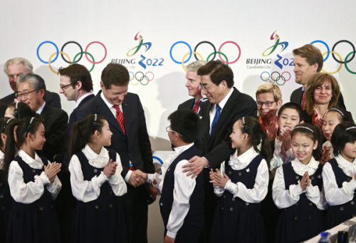 Alexander Zhukov (center left), chairman of the International Olympic Committee's evaluation commission, and Guo Jinlong, Party chief of Beijing, greet a primary school student after a wrap-up news conference for the commission's inspection visit to Beijing on Saturday. (Photo: China Daily/Feng Yongbin)