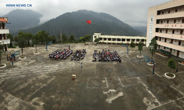 Teachers and students at the Hekou Middle School are evacuated to the playground after an earthquake in Jinping County, southwest China's Guizhou Province, March 30, 2015. A 5.5-magnitude quake struck Jianhe County in southeast Guizhou on Monday rocking several neighboring counties. More than 13,000 residents of 2,200 households in Jianhe were affected by the quake, according to the provincial civil affairs department. (Xinhua/Yang Tongping)