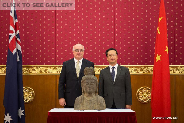 Chinese Ambassador to Australia Ma Zhaoxu (R) and Australia's Minister for the Arts Senator George Brandis pose for photos with the Qing Dynasty Guanyin statue which was illegally exported to Australia in 2013 at the return ceremony in Canberra, Australia, March 5, 2015. During a ceremony at the Chinese Embassy in Canberra on Thursday, the statue of Guanyin, revered by Buddhists, was handed over by the Australian government, in accordance with a bilateral commitment to return and protect cultural property. (Photo: Xinhua/Justin Qian)
