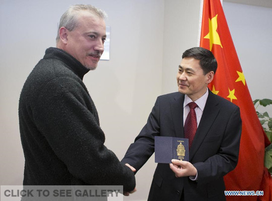 Xue Bing (R), China's Consul General to Toronto, hands the first visa to China with validity period of up to 10 years to Timothy Mark Hay at Chinese Visa Application Service Center in Toronto, Canada, March 9, 2015. Chinese embassy and consulates in Canada began to grant visas to Canadian citizens with the validity period of up to 10 years on March 9, 2015, according to the agreement which was just reached earlier between the two countries. (Xinhua/Zou Zheng) 