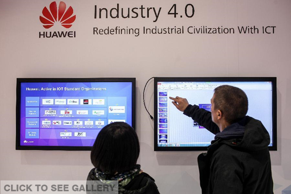 Two staff members work at Huawei's stand of the 2015 CeBIT Technology Trade fair in Hanover, Germany, on March 14, 2015. As the partner country of CeBIT 2015, the world's leading information technology trade fair, China would send over 600 exhibitors to the annual trade fair in Hanover in March. (Photo: Xinhua/Zhang Fan)