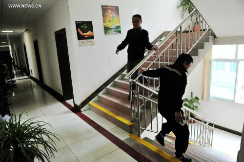 People run off stairs at a building in Congjiang County, close to Jianhe County, southwest China's Guizhou province, March 30, 2015. A 5.5-magnitude quake struck Jianhe county in Guizhou province Monday, according to the China Earthquake Networks Center. (Xinhua/Liang Guangyuan)