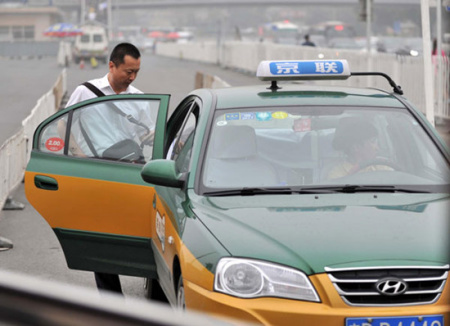 A man takes a taxi near Beijing Railway Station, June 6, 2013. [Photo/Xinhua]