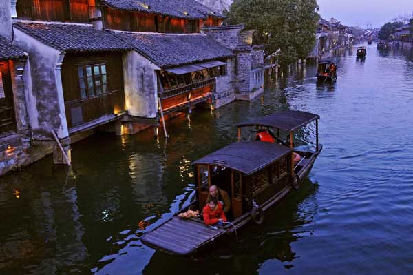 Tourists visit Wuzhen, Zhejiang province on a boat on Jan 2. (Photo/Xinhua)